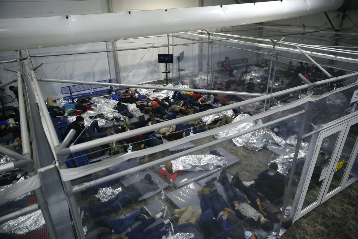 Minors lie inside a pod at the Donna Department of Homeland Security holding facility, the main detention center for unaccompanied children in the Rio Grande Valley run by the U.S. Customs and Border Protection in Donna, Texas, on March 30, 2021. (Dario Lopez-Mills/Pool/AP Photo)