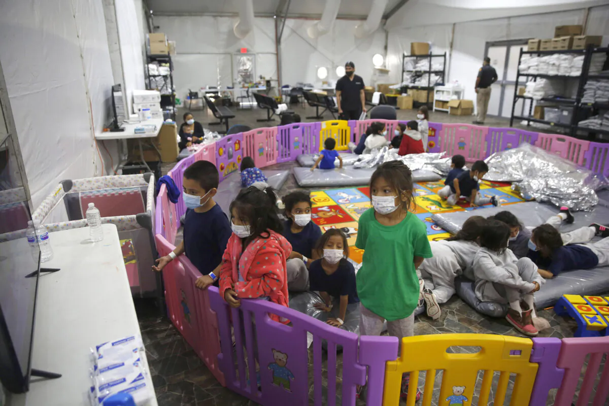 Young unaccompanied illegal immigrants, from ages 3 to 9, watch television inside a playpen at the U.S. Customs and Border Protection facility, the main detention center for unaccompanied children in the Rio Grande Valley, in Donna, Texas, on March 30, 2021. (Dario Lopez-Mills/Pool/AP Photo)