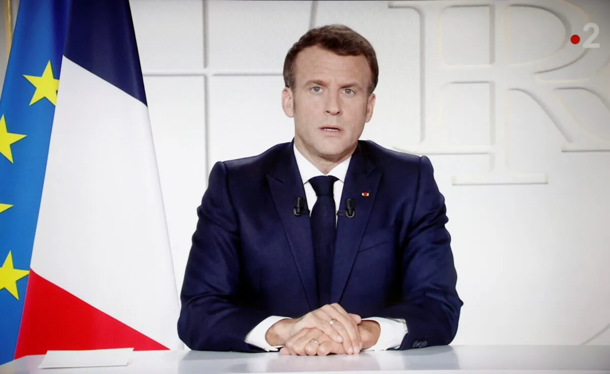French President Emmanuel Macron is seen on a screen as he addresses the nation about the state of the CCP virus outbreak as a fast-spreading third wave of COVID-19 infections threatens to over-run hospitals in France, on March 31, 2021. (Stephane Mahe/Reuters)