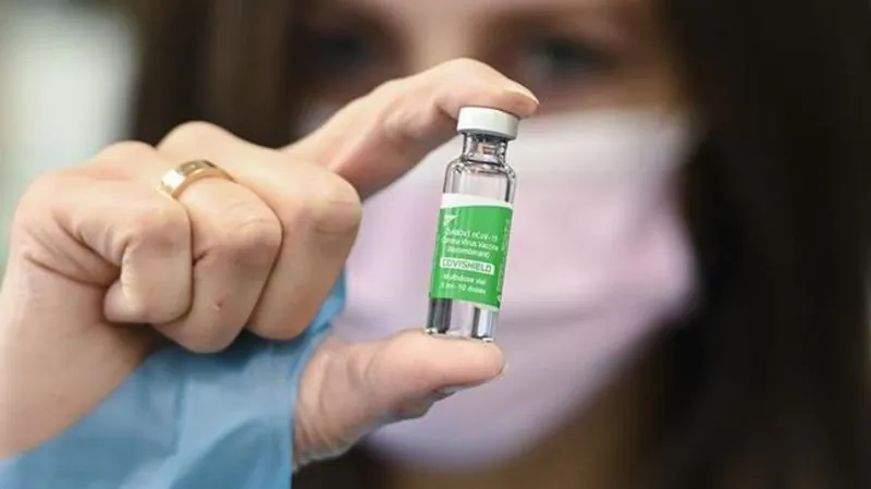 A pharmacist shows off a vial of the Oxford-AstraZeneca COVID-19 vaccine after providing doses to customers at the Junction Chemist during the COVID-19 pandemic in Toronto on March 12, 2021. (Nathan Denette / The Canadian Press)
