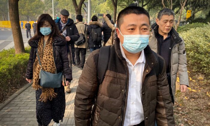 Lawyer Ren Quanniu (C), representing Chinese citizen journalist Zhang Zhan who reported on the virus outbreak, arrives at the Shanghai Pudong New District People's Court where Zhang is set for trial in Shanghai on Dec. 28, 2020. (Leo Ramirez/AFP via Getty Images)