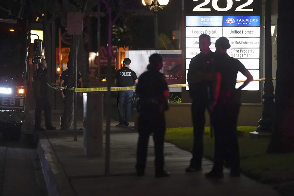 Police officers stand outside a business building where a shooting occurred in Orange, Calif., on March 31, 2021. (AP Photo/Jae C. Hong)