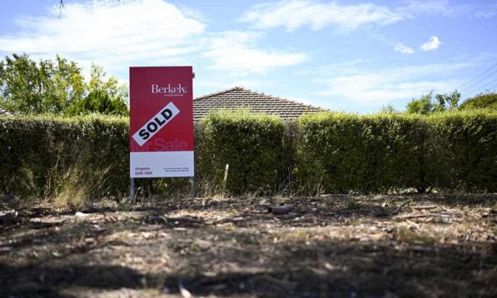 A real estate advertising board is seen next to a house in Canberra, Australia, March 1, 2019. (AAP Image/Lukas Coch)