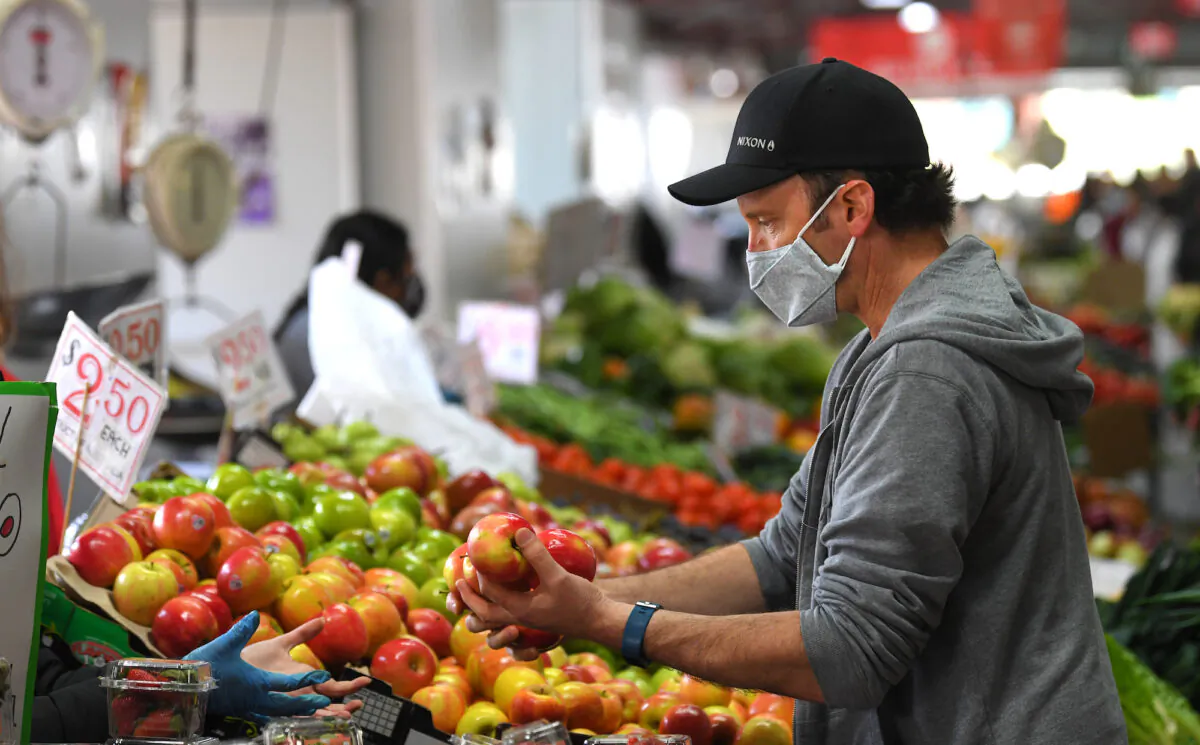 People are seen shopping for fruit and vegetables at the Queen Victoria Market in Melbourne, Sunday, Oct. 18, 2020. (AAP Image/James Ross)
