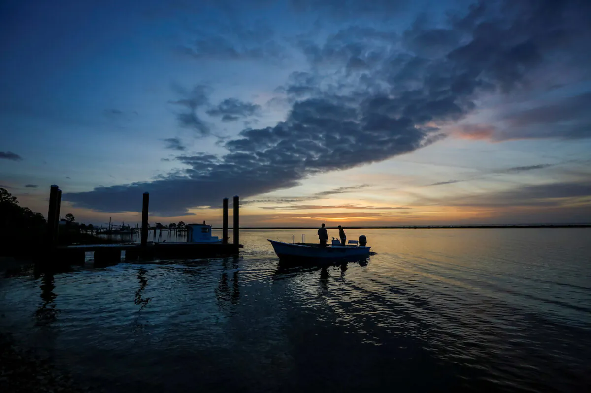 A boat leaves before dawn for a day of work harvesting oysters from Apalachicola Bay, Feb. 11, 2020. (Colin Hackley/Reuters)