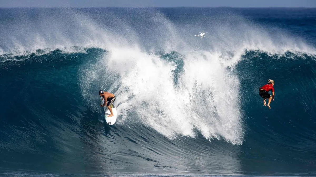 A surfer rides a wave as another one gets wiped out at Pipeline on the north shore of Oahu, Hawaii, on Feb. 14, 2021. (Brian Bielmann/AFP via Getty Images)
