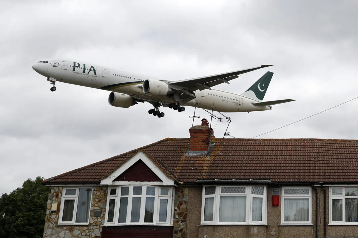 A Pakistan International Airlines Boeing 777 comes in over houses, to land at Heathrow airport in west London on June 8, 2020. (Adrian Dennis/AFP via Getty Images)