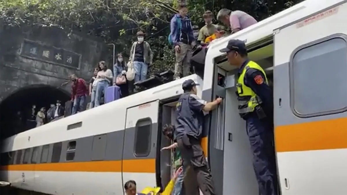 In this image made from a video released by hsnews.com.tw, passengers are helped to climb out of a derailed train in Hualien County in eastern Taiwan, on April 2, 2021. (hsnews.com.tw via AP)