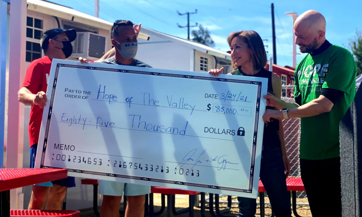 Actor Jon Cryer (R) and his wife, entertainment reporter Lisa Joyner (2nd from R), present a check to representatives of Hope of the Valley, a nonprofit that helps the homeless, in the North Hollywood neighborhood of Los Angeles on March 24, 2021. (Jamie Joseph/The Epoch Times) 