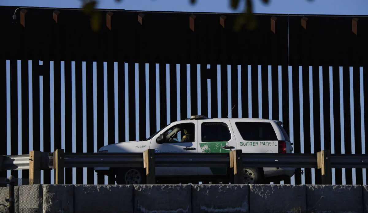 A U.S. Border Patrol agent sits in a vehicle along a border wall near the U.S. Customs and Border Protection (CBP) San Ysidro Port of Entry at the U.S. Mexico border in San Diego, Calif., on Feb. 19, 2021. (Patrick T. Fallon/AFP via Getty Images)