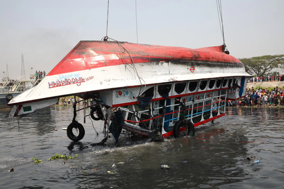 The ferry that collided with a cargo vessel and sank on Sunday in the Shitalakhsyaa River is pulled out from the river with a crane, during rescue operations in Narayanganj, Bangladesh on April 5, 2021. (Mohammad Ponir Hossain/Reuters)