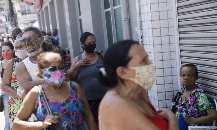 People wait in line to receive a dose of the Sinovac's CoronaVac vaccine during a vaccination day for 65-year-old and older citizens in Duque de Caxias near Rio de Janeiro, Brazil, on March 29, 2021. (Ricardo Moraes/Reuters)