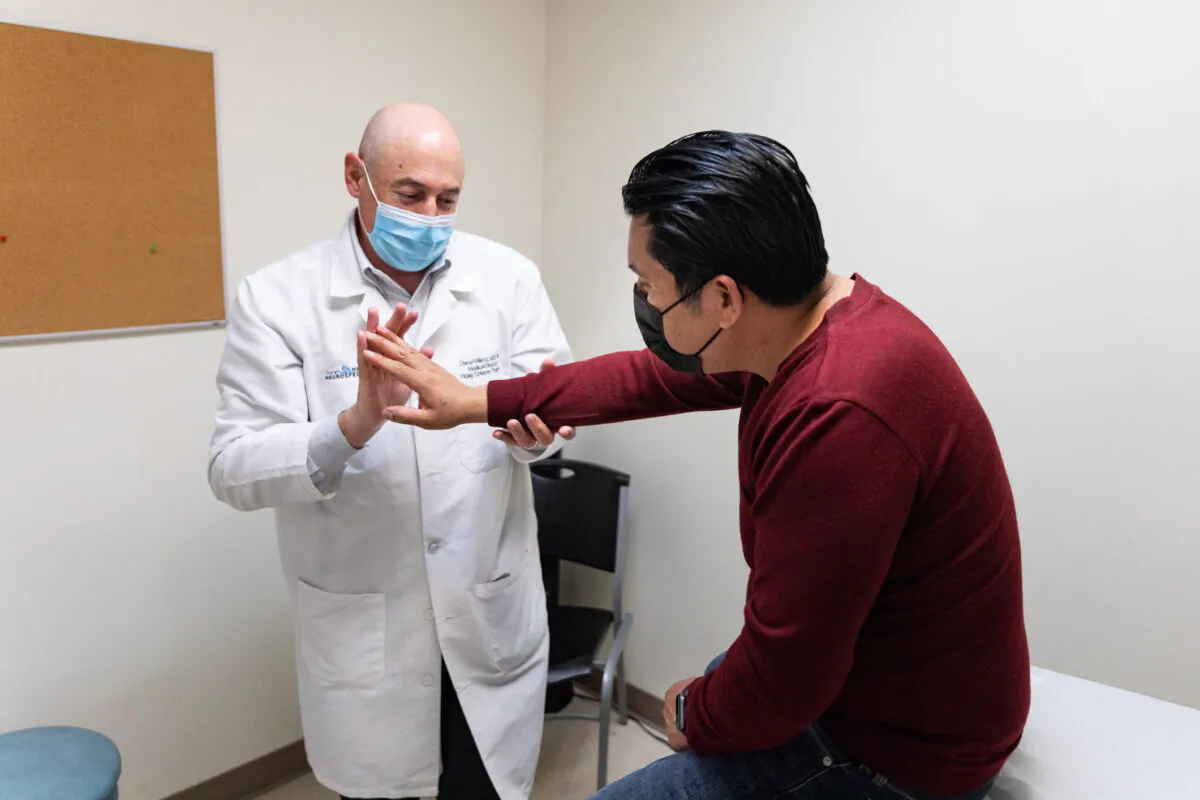 Patient Israel Zuniga (R) receives treatment from Dr. David Millet at the Lestonnac Free Clinic in Orange, Calif., on March 19, 2021. (John Fredricks/The Epoch Times)