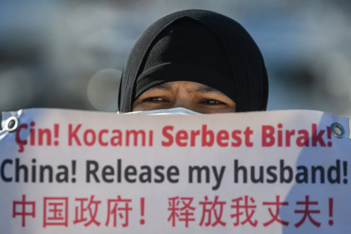 A Uyghur holds a sign asking the Chinese regime to release her husband at a parade near the Chinese consulate in Istanbul, Turkey on Feb. 22, 2021. (Ozan Kose/AFP via Getty Images)
