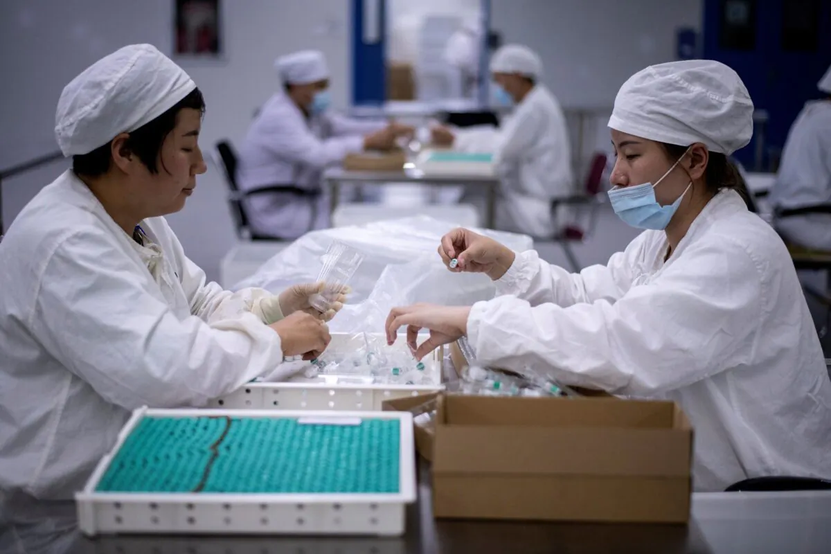 Workers package rabies vaccine at a lab where researchers are trying to develop a vaccine for the COVID-19 coronavirus, in Shenyang, in China's northeast Liaoning province, on June 9, 2020. (Noel Celis/AFP via Getty Images)