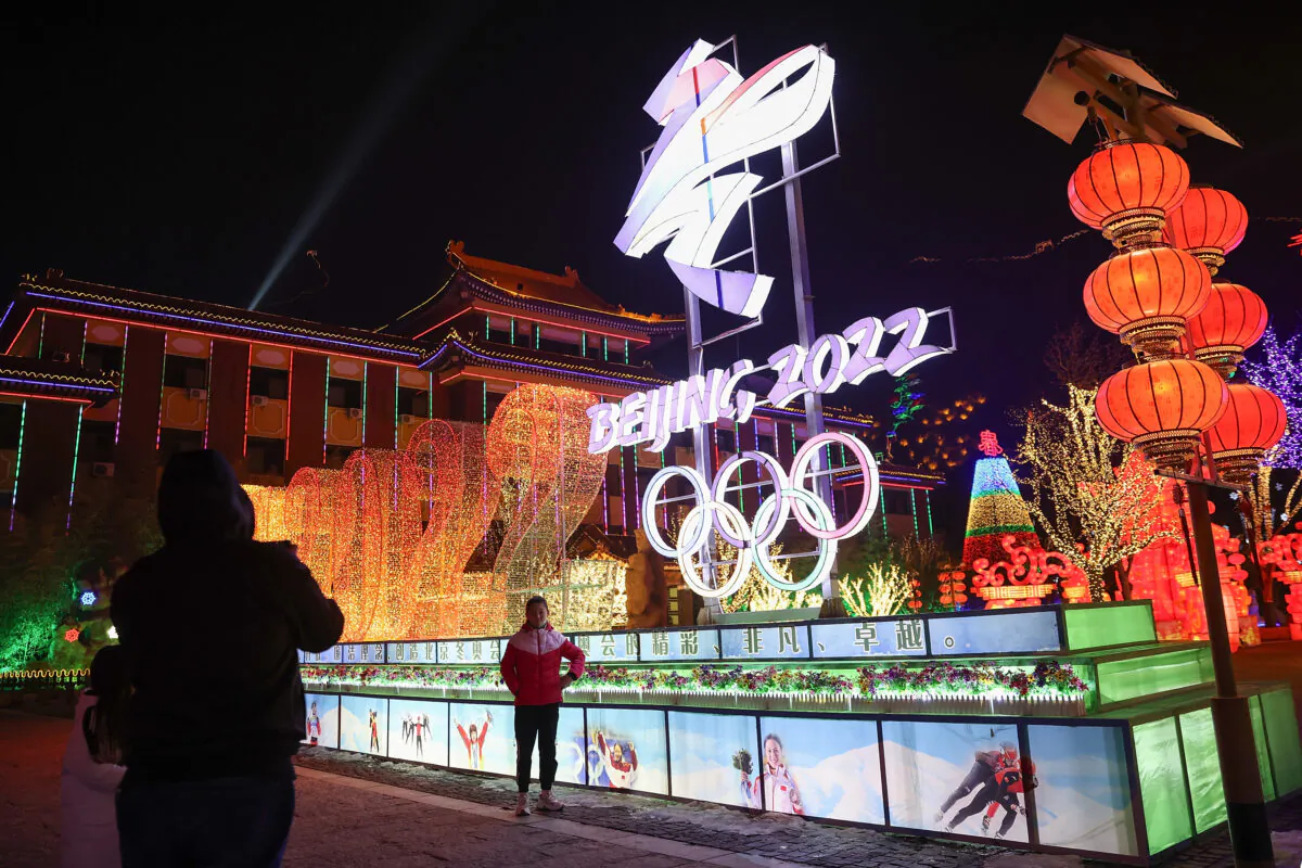 People near 2022 Beijing Winter Olympics logos at Yanqing Ice Festival in Beijing, China, on Feb. 26, 2021. (Lintao Zhang/Getty Images)