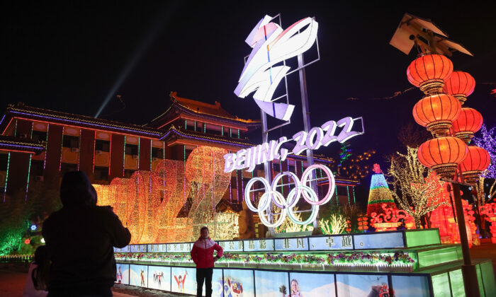 People near 2022 Beijing Winter Olympics logos at Yanqing Ice Festival in Beijing, China, on Feb. 26, 2021. (Lintao Zhang/Getty Images)