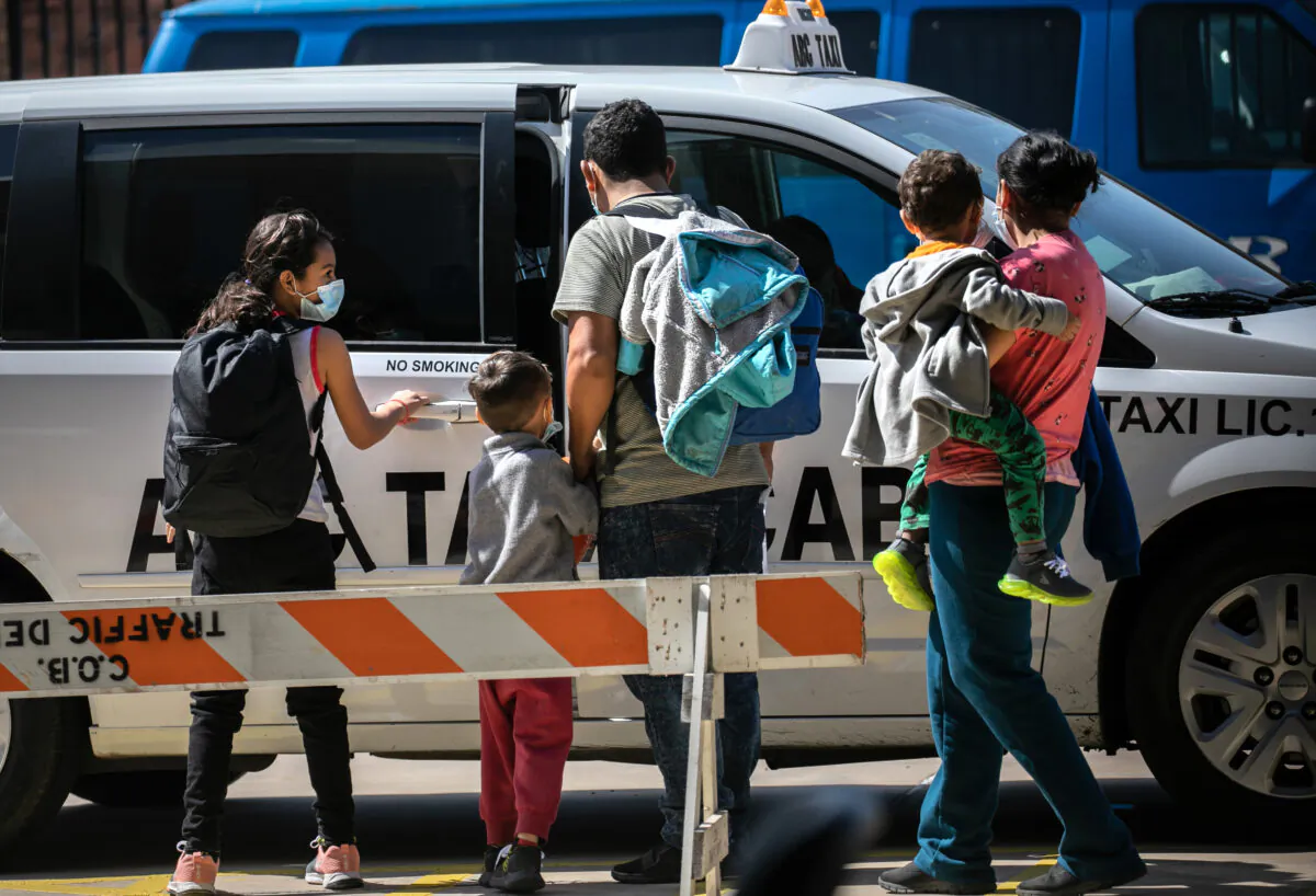 A family group of asylum seekers takes a taxi to the airport for onward travel within the United States after being released by immigration authorities in Brownsville, Texas, on Feb. 24, 2021. (John Moore/Getty Images)