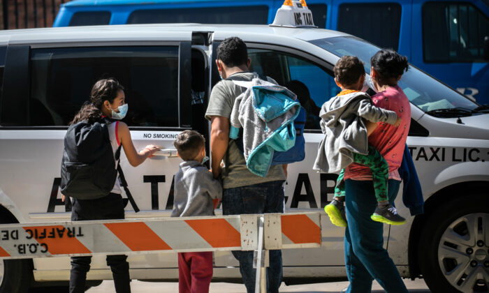 A family group of asylum seekers takes a taxi to the airport for onward travel within the United States after being released by immigration authorities in Brownsville, Texas, on Feb. 24, 2021. (John Moore/Getty Images)