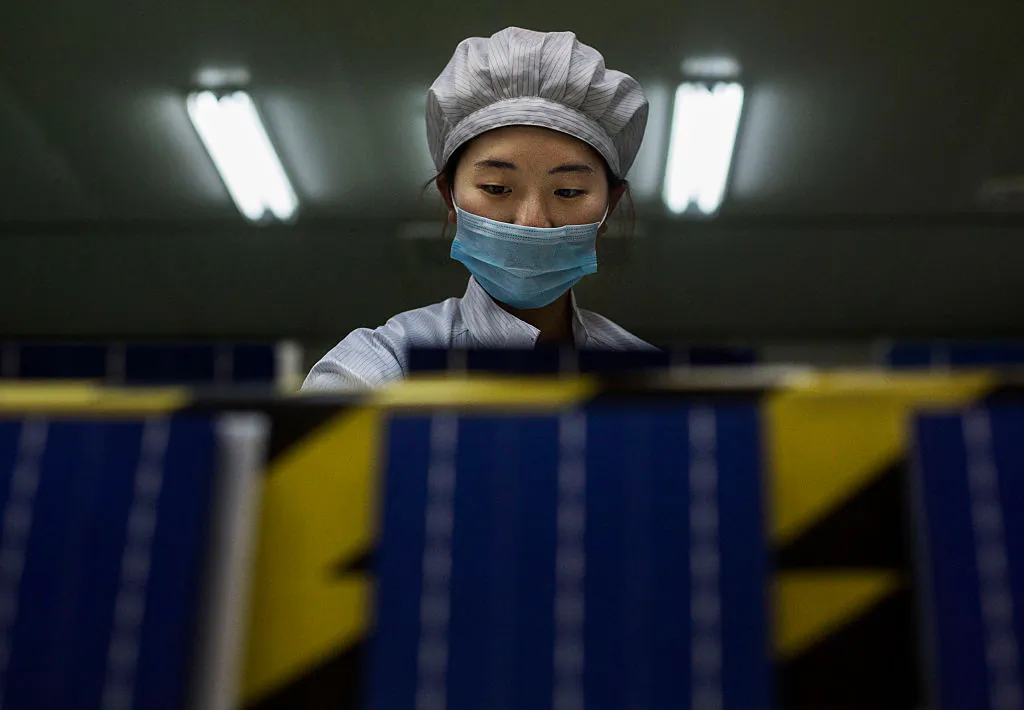 A technician from Yingli Solar prepares solar cells in Hebei Province, China, on Dec. 4, 2014. (Photo by Kevin Frayer/Getty Images)