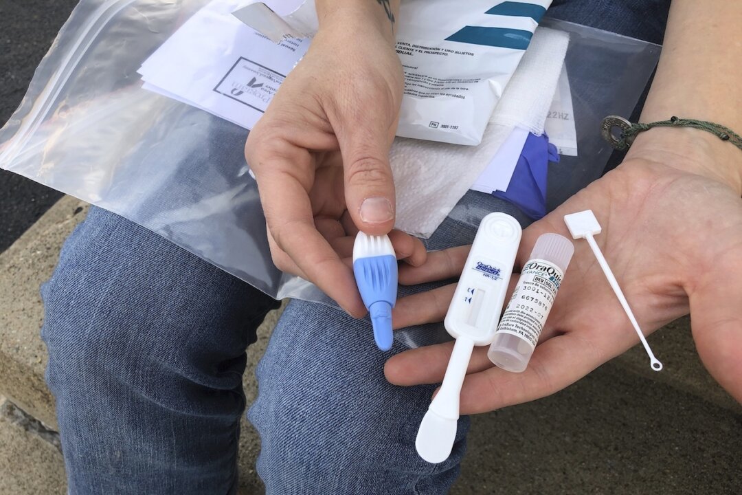 A person holds an HIV testing kit in Charleston, W.Va., on March 9, 2021. (John Raby/AP Photo)