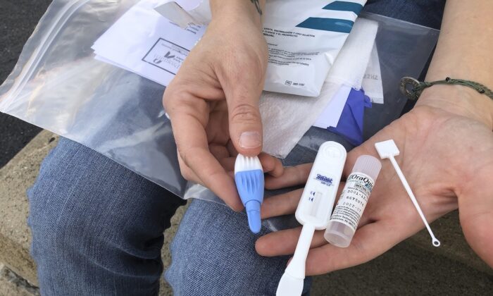 A person holds an HIV testing kit in Charleston, W.Va., on March 9, 2021. (AP Photo/John Raby)