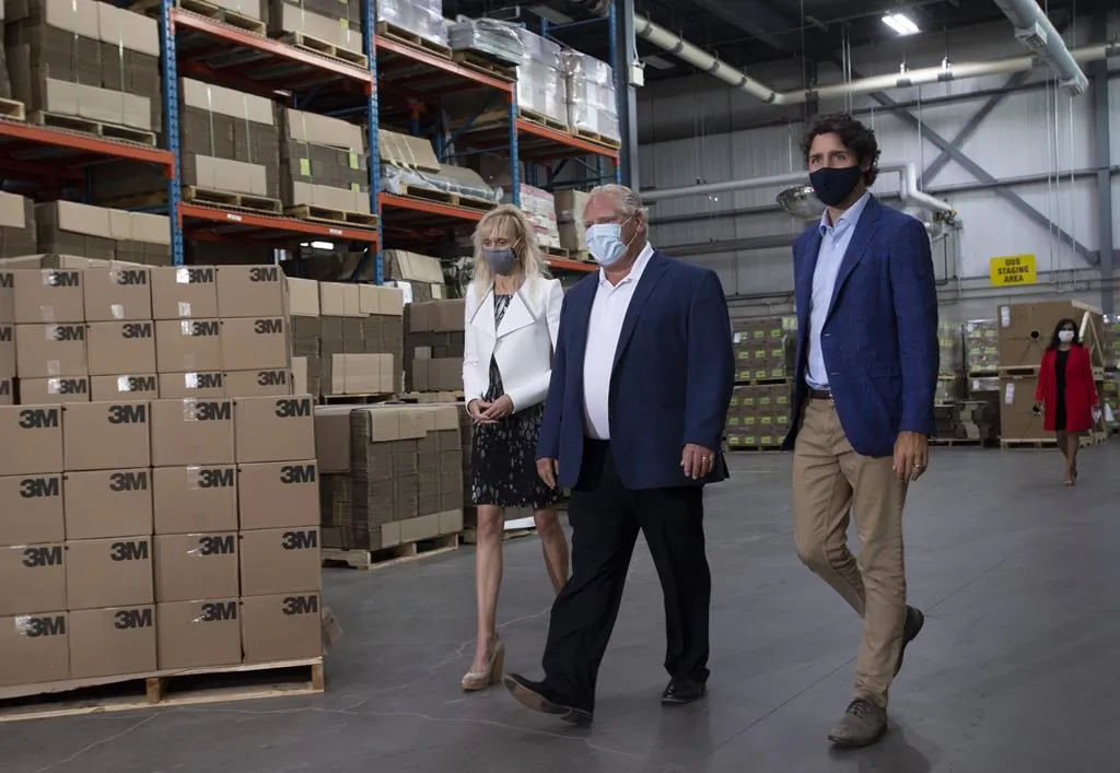 3M Canada President Penny Wise, Ontario Premier Doug Ford and Prime Minister Justin Trudeau make their way to an announcement at a facility in Brockville, Ont., on Aug. 21, 2020. (Adrian Wyld/The Canadian Press)