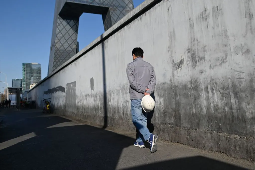A worker, seen holding his hard-hat, walks toward to a construction site in Beijing on Jan. 23, 2019. - China's economy grew at its slowest pace in almost three decades in 2018, losing more steam in the last quarter as it battles a massive debt pile and a U.S. trade war. (WANG ZHAO/AFP via Getty Images)