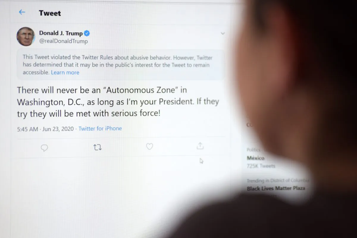 This illustration photo shows a woman in Los Angeles looking at the official Twitter account of then-President Donald Trump on June 23, 2020. (AFP via Getty Images)