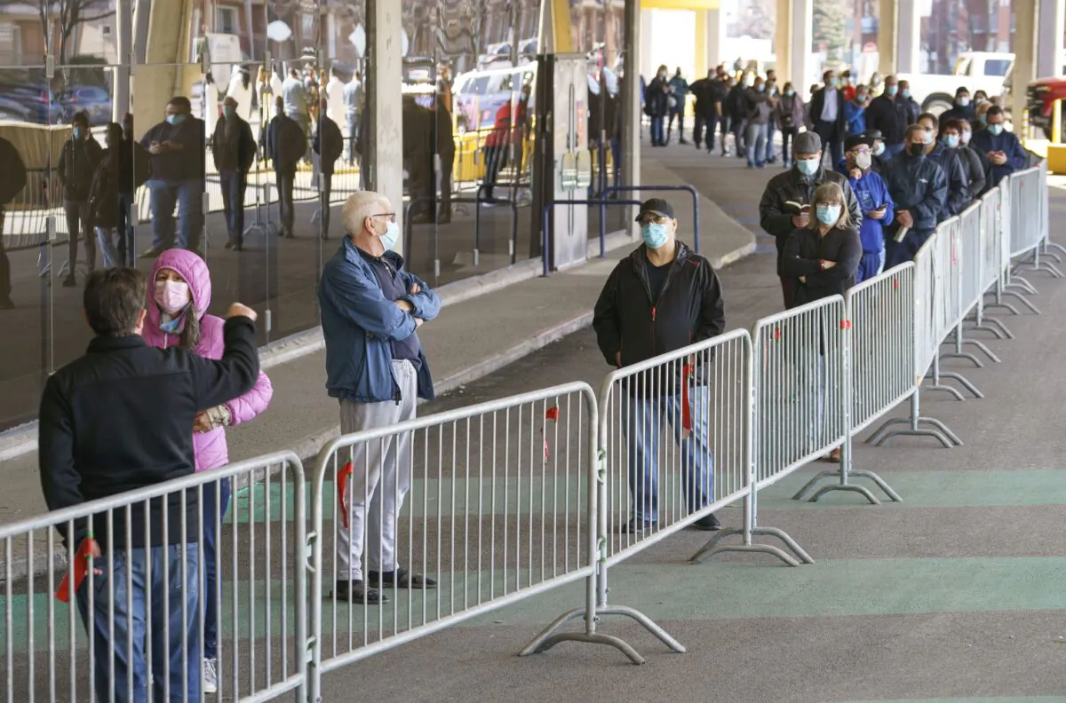 People wait in line at a COVID-19 vaccination clinic at Olympic Stadium in Montreal on April 8, 2021. (The Canadian Press/Paul Chiasson)