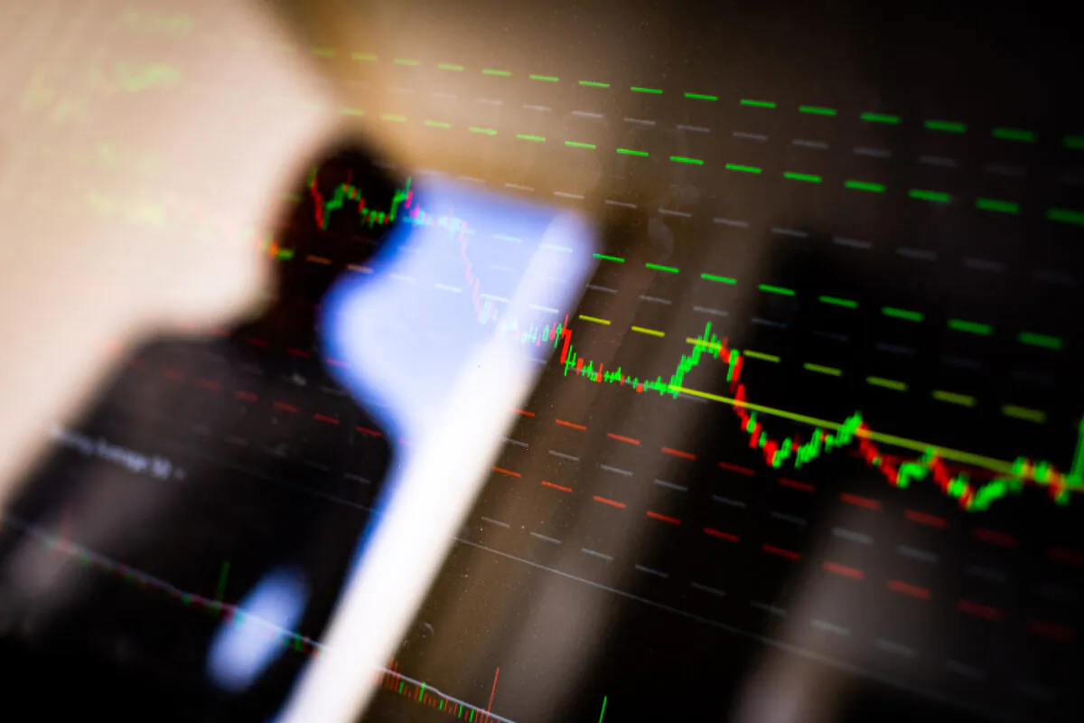 A man looks at a stock market chart in Irvine, Calif., on April 9, 2021. (John Fredricks/The Epoch Times)