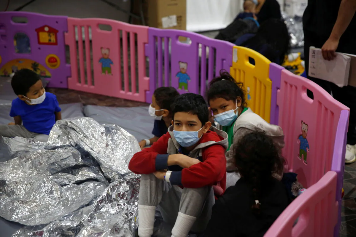 Young unaccompanied migrants, that range in age from 3 to 9, sit inside a play pen at the U.S. Customs and Border Protection facility, the main detention center for unaccompanied children in the Rio Grande Valley, in Donna, Texas, on March 30, 2021. (Dario Lopez-Mills/Pool via Reuters)