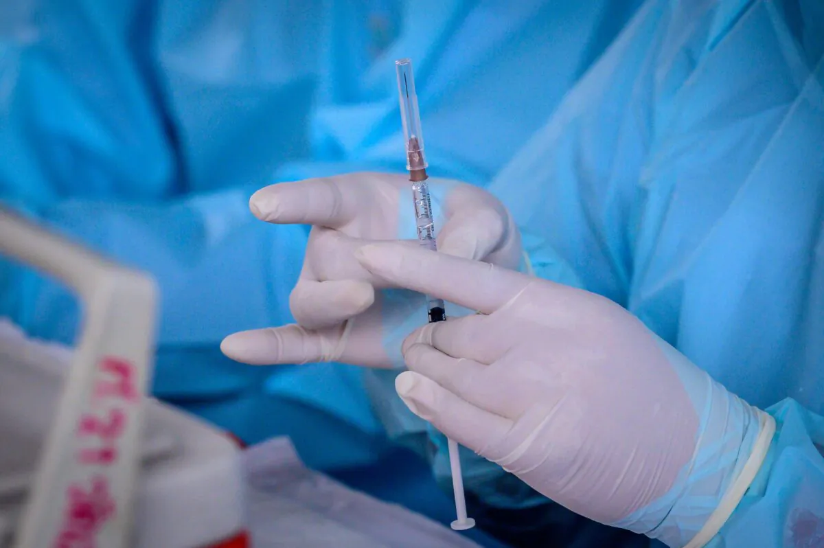 A health worker prepares to administer the COVID-19 CoronaVac vaccine, developed by China's Sinovac firm, at a makeshift clinic at Saeng Thip sports ground in Bangkok, Thailand, on April 7, 2021. (Mladen Antonov/AFP via Getty Images)
