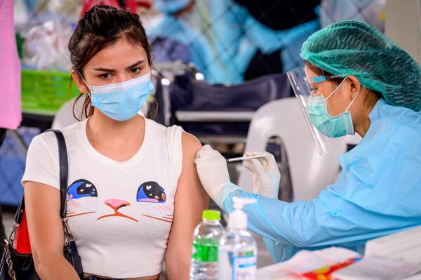 A health worker administers the CoronaVac vaccine, developed by China’s Sinovac firm, to a woman from an at-risk group at Saeng Thip sports ground in Bangkok, Thailand, on April 7, 2021. (Mladen Antonov/AFP via Getty Images)