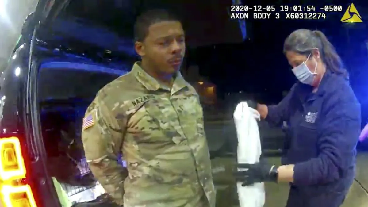 In this image made from Windsor, (Va.) Police video, Caron Nazario is helped by an EMT after he was sprayed with an agent by Windsor police after a traffic stop on Dec. 20, 2020, in Windsor, Va.  Nazario, a second lieutenant in the U.S. Army, is suing two Virginia police officers over a traffic stop during which he says the officers drew their guns and pointed them at him as he was dressed in uniform. Caron Nazario says his constitutional rights were violated by the traffic stop in the town of Windsor in December. (Windsor Police via AP)