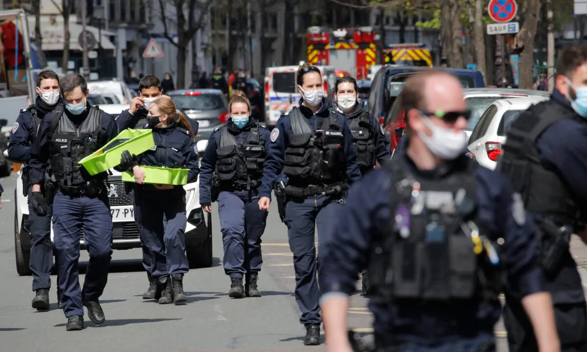 Police officers leave the scene after a shooting in Paris, France, on April 12, 2021. (Christophe Ena/AP Photo)
