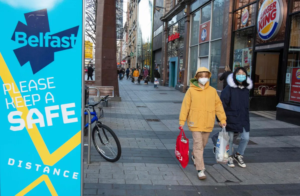 Shoppers wearing protective face coverings to combat the spread of the CCP virus, walk through Belfast city centre, in Northern Ireland, UK, on Dec. 24, 2020. (Paul Faith /AFP via Getty Images)