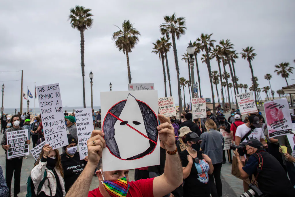A protester holds an anti-Ku Klux Klan sign during a demonstration against white supremacy in Huntington Beach, Calif., on April 11, 2021. (Apu Gomes/Getty Images) 
