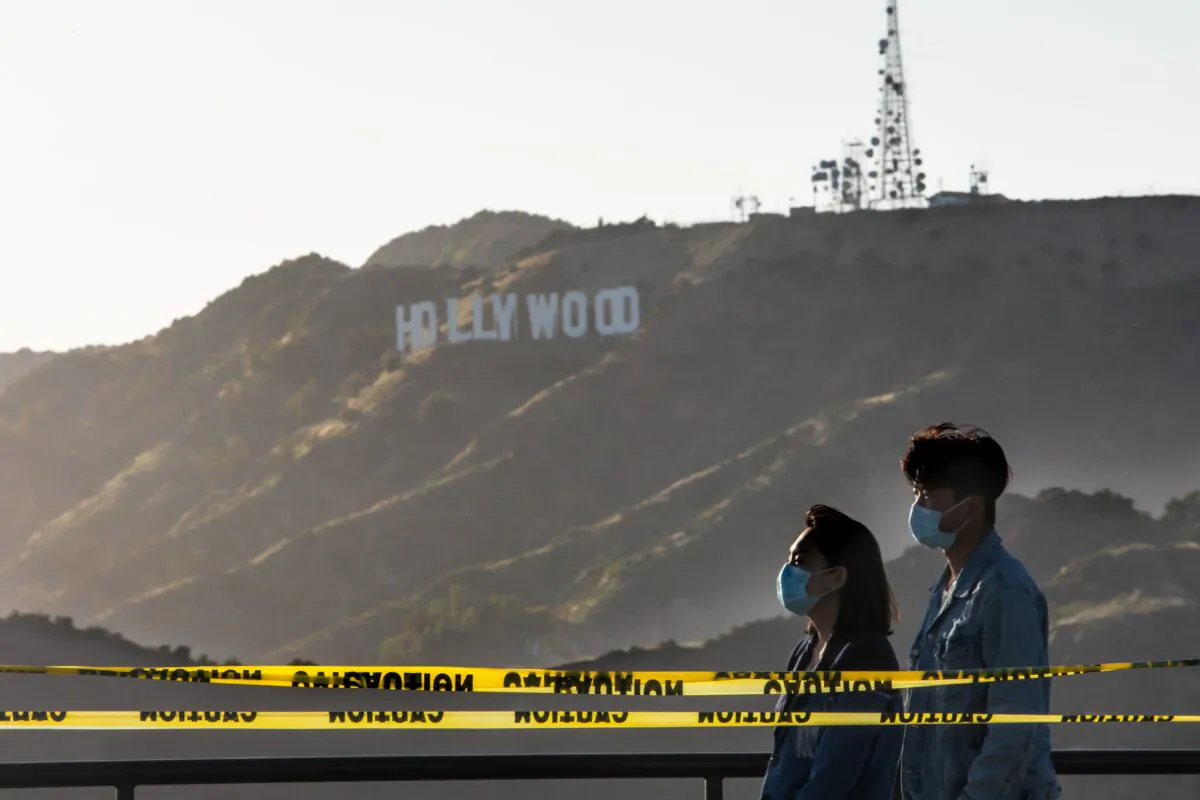 People walk at the Griffith Observatory with a view of the Hollywood sign in Los Angeles, Calif., on May 22, 2020. (Apu Gomes/AFP via Getty Images)