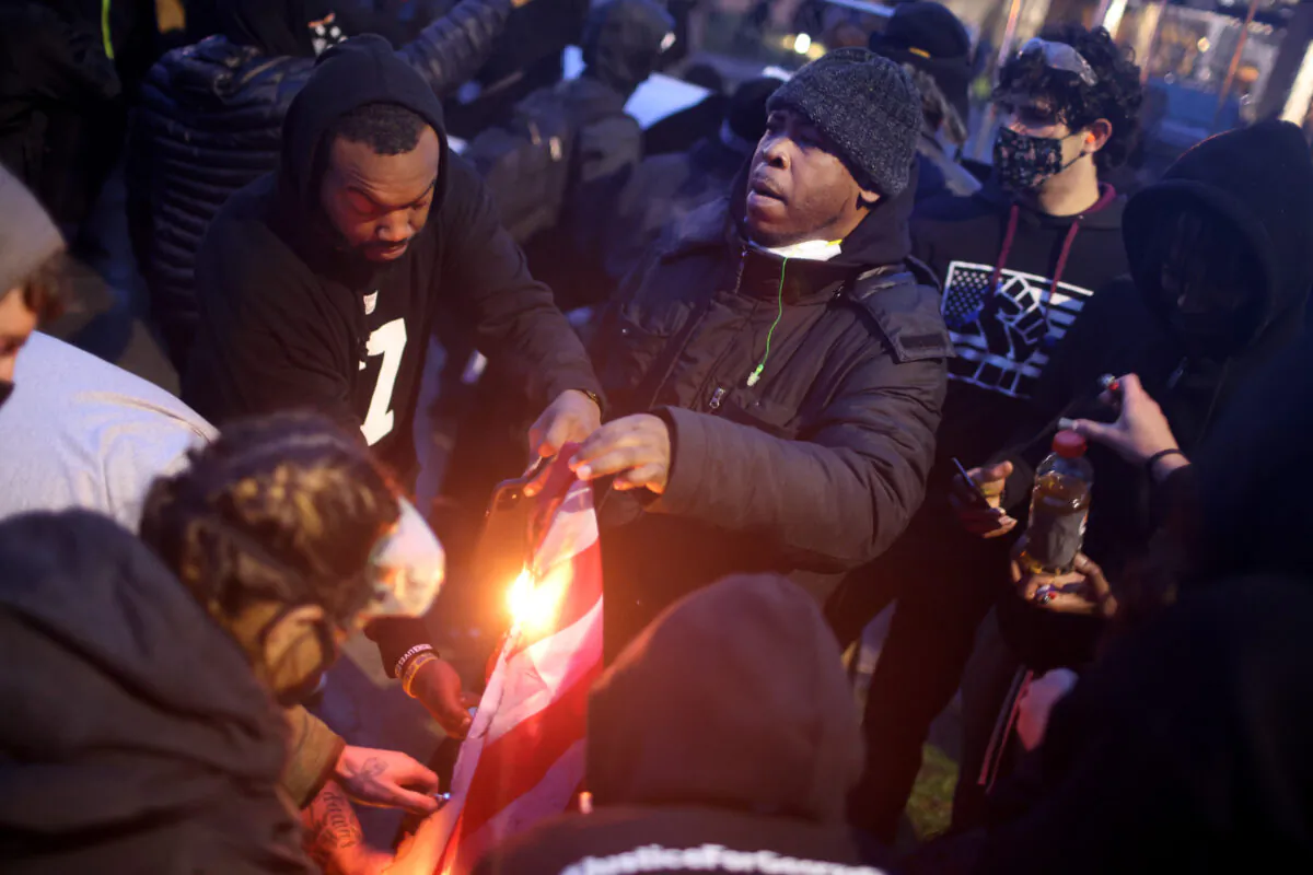 Demonstrators burn a flag outside the Brooklyn Center police station in Brooklyn Center, Minn., on April 12, 2021. (Scott Olson/Getty Images)