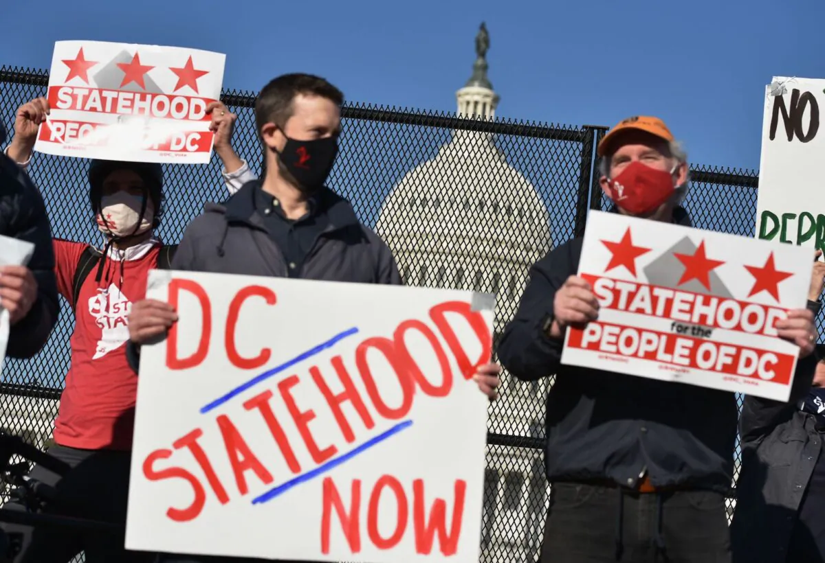 Activists hold signs as they take part in a rally in support of DC statehood near the US Capitol in Washington D.C., on March 22, 2021. (Mandel Ngan/AFP via Getty Images)