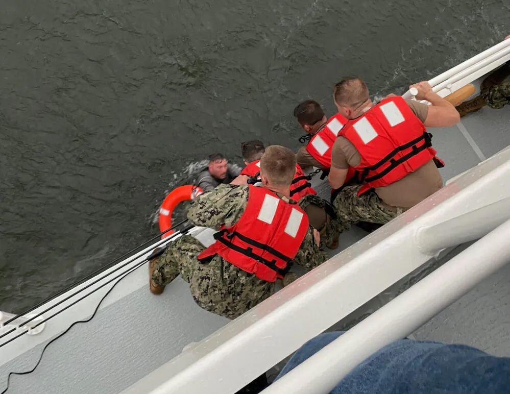 The crew of the Coast Guard Cutter Glenn Harris pulls a person from the water after a 175-foot commercial lift boat capsized 8 miles south of Grand Isle, Louisiana, on April 13, 2021. (USCG/Coast Guard Cutter Glenn Harris)