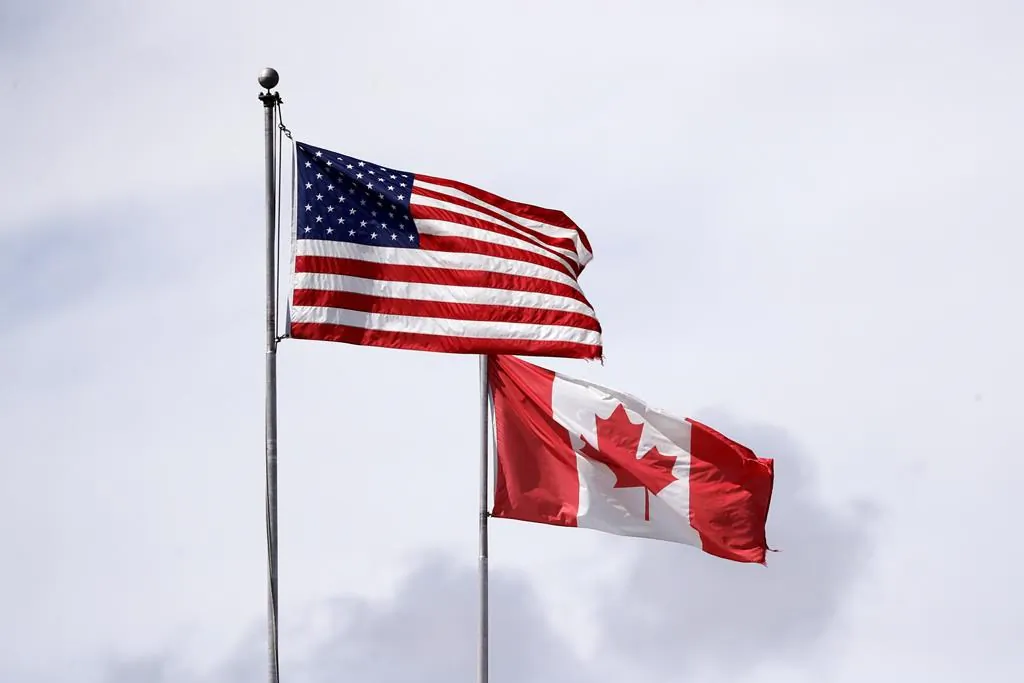 U.S. and Canadian flags fly atop the Peace Arch at Peace Arch Historical State Park on the border with Canada in Blaine, Wash., in a file photo. (AP Photo/Elaine Thompson)