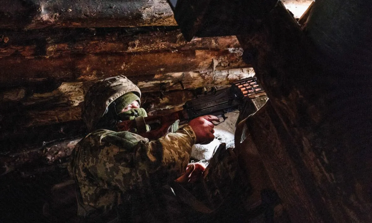 A Ukrainian serviceman keeps ready a machine gun in his shelter near the front-line town of Krasnohorivka, eastern Ukraine, on March 5, 2021. (Evgeniy Maloletka/AP Photo)