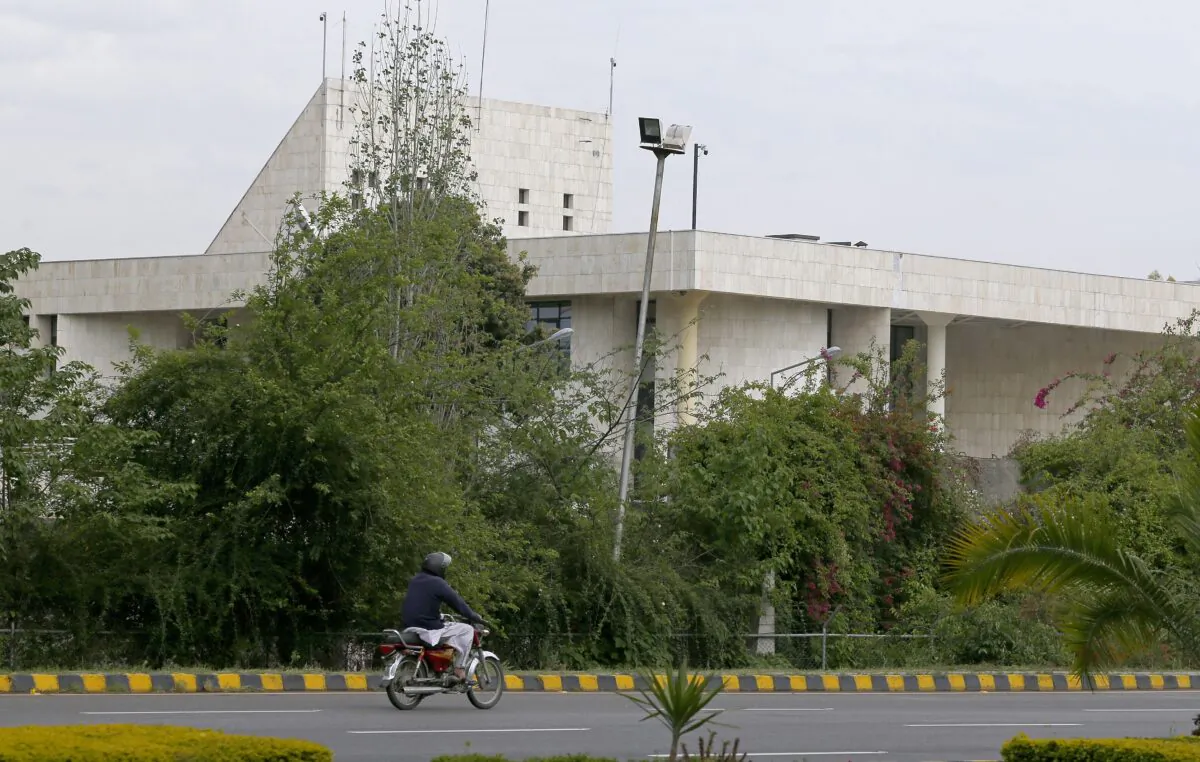 A motorcyclist rides past the French Embassy, in Islamabad, Pakistan, on April 15, 2021. (Anjum Naveed/AP Photo)