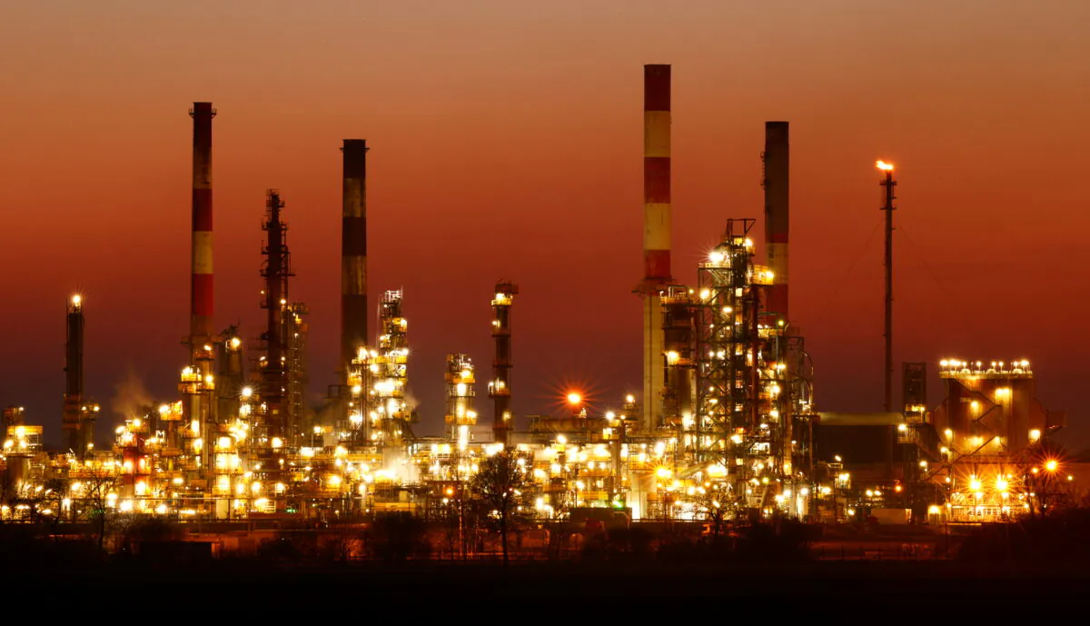 The chimneys of the Total Grandpuits oil refinery are seen just after sunset, southeast of Paris, France, on March 1, 2021. (Christian Hartmann/Reuters)