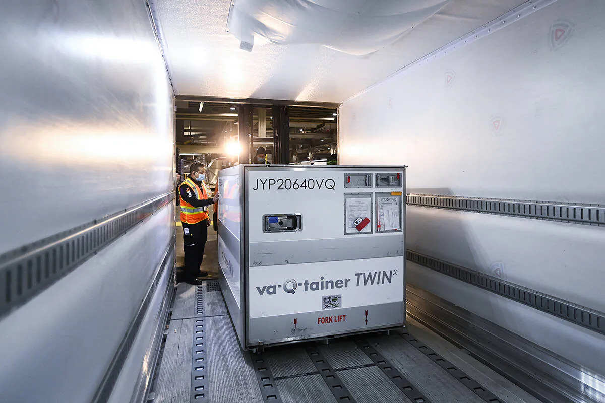 A FedEx worker loads the 255,600 doses of the Moderna COVID‑19 vaccine which came from Europe into a freezer trailer to be transported during the COVID-19 pandemic at Pearson International Airport in Toronto on March 24, 2021. (Nathan Denette/The Canadian Press)