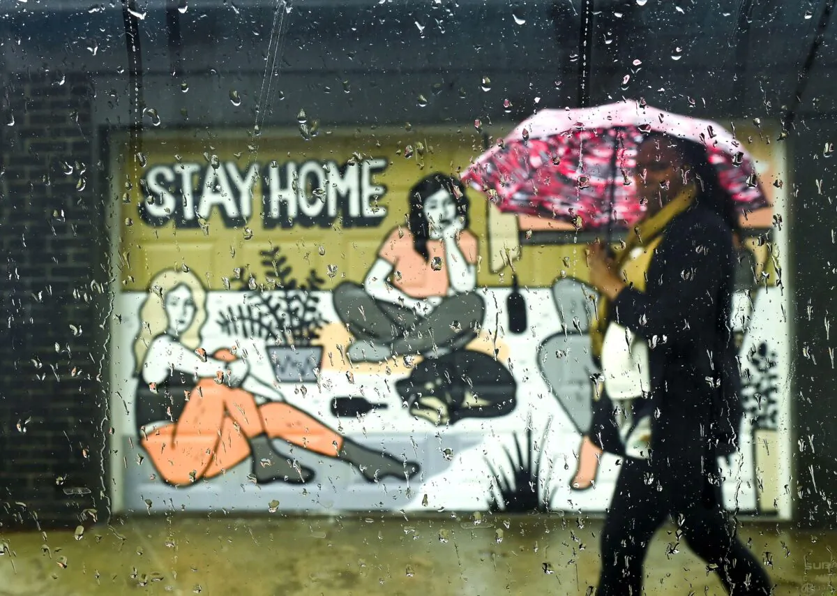 A woman walks past a COVID-19 mural in Toronto on April 12, 2021. (The Canadian Press/Nathan Denette)