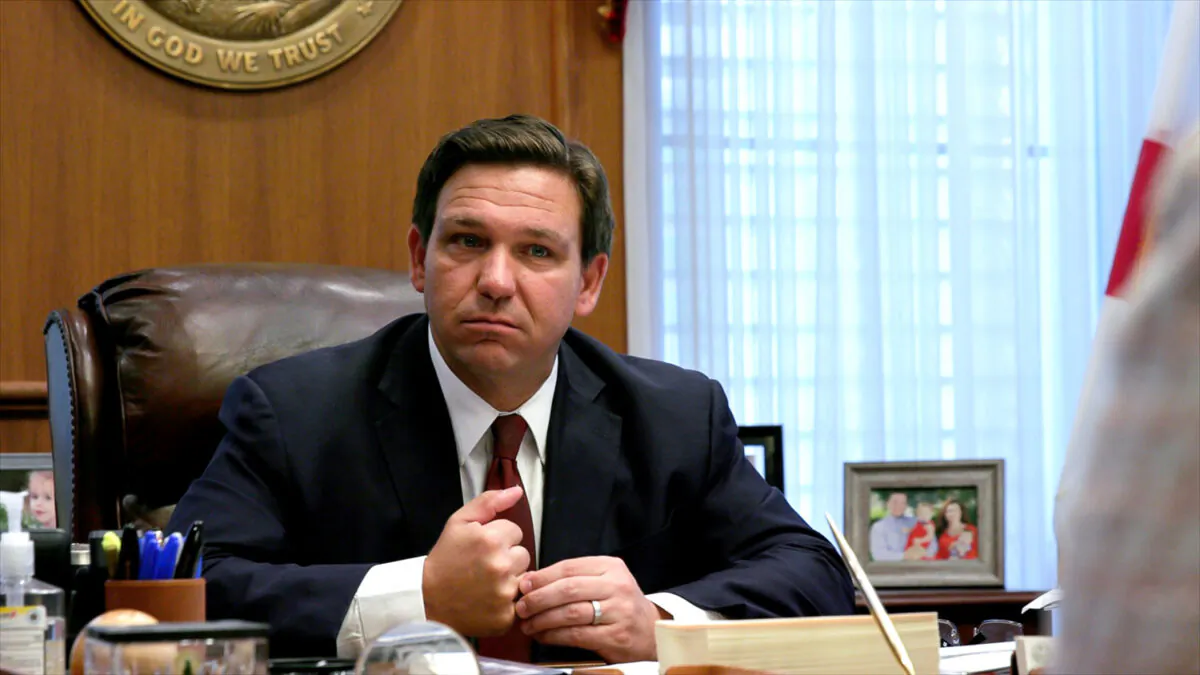 Floridа Gov. Ron DeSantis listens to a report from a member of his administration during a meeting at the governor's office in Tallahassee, Fla., on April 1, 2021. (Screenshot via The Epoch Times)
