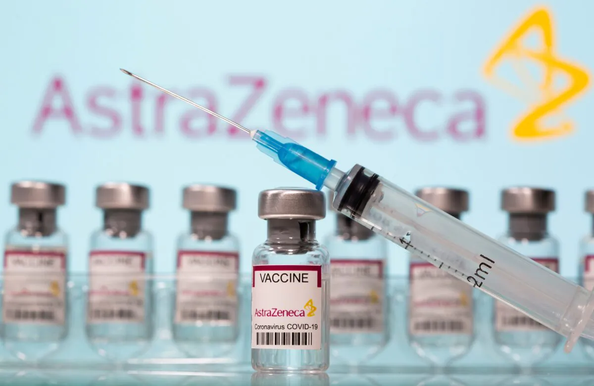 Vials labelled "AstraZeneca COVID-19 Coronavirus Vaccine" and a syringe are seen in front of a displayed AstraZeneca logo in this illustration taken March 10, 2021. (Dado Ruvic/Illustration/Reuters)